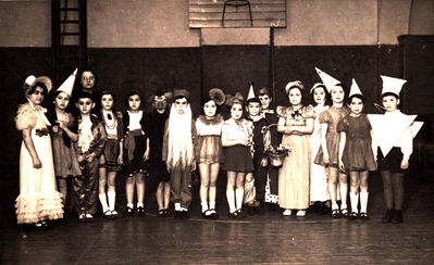 Tallinn - 1938. Purim in Tallinn Jewish school.  1A class. 1938.
Left to right: Dori Scheskin, ?, Jascha Gordon?, the teacher Hatskin, Juza Rubinstein, Ita Slatkin, Njoma ?, Lev (Haim) Judeikin,  Mia ?, Lia Braschinsky, Jossi Pakin, Henni Lipelis, Lilly Schulmann,  Sara Mirvits? Vasser?, ?, Borja Gurevitsch? 
